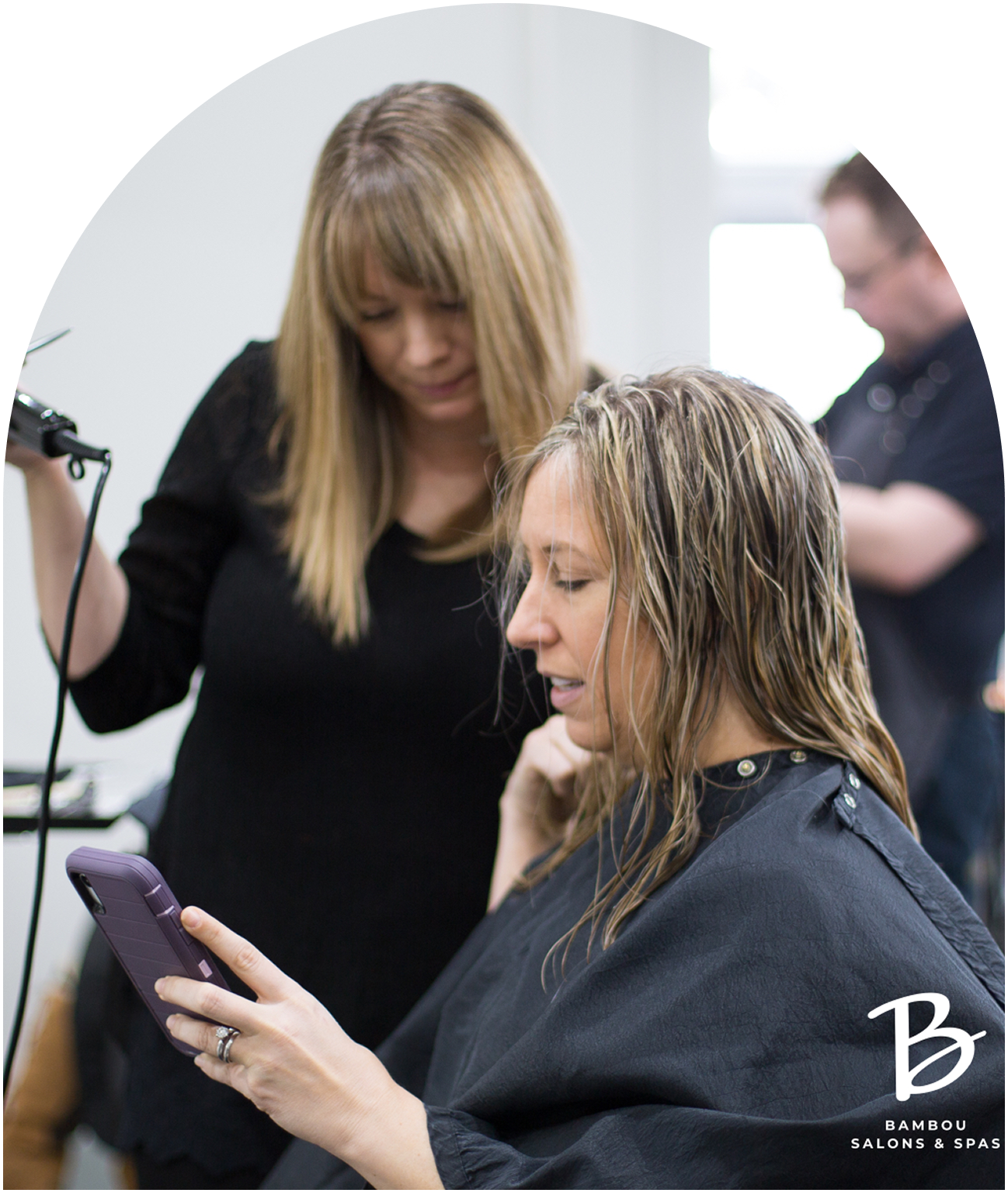 Hair stylist working on a customer's hair in a salon.