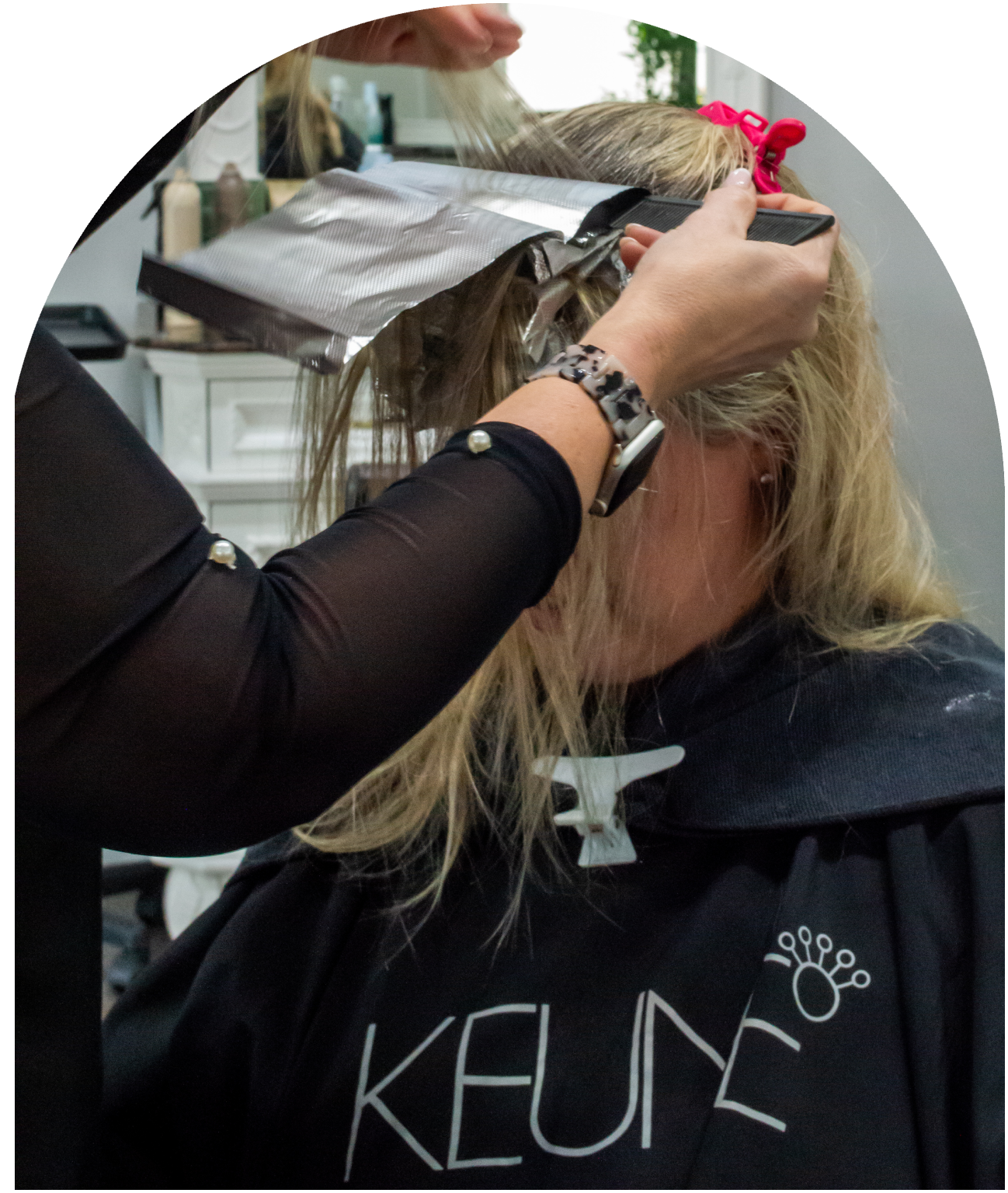 A woman getting her hair styled in a salon.